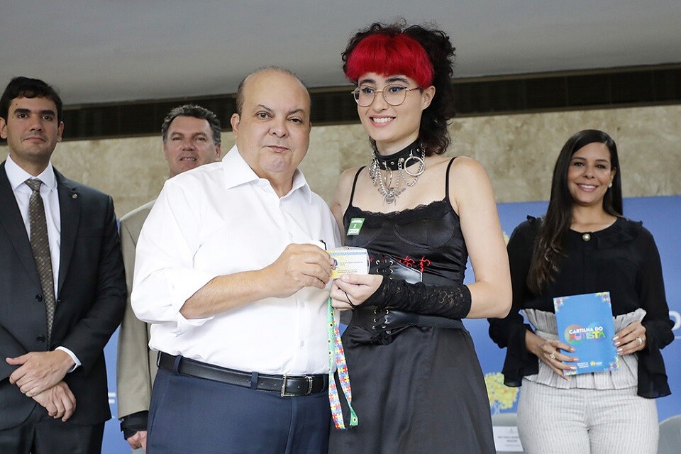 O governador Ibaneis Rocha entrega a carteira à estudante Julia Stavros