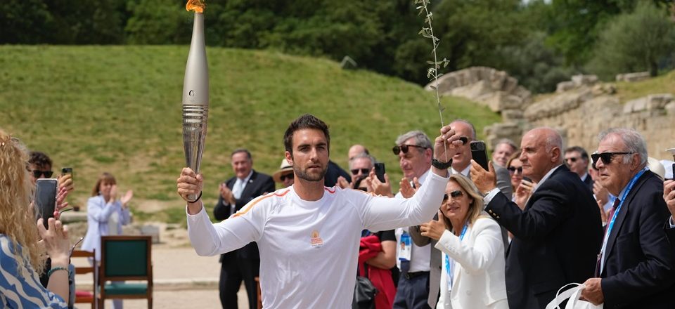 O remador grego Stefanos Ntouskos, campeão olímpico em Tóquio, iniciou o circuito com a tocha e um ramo de oliveira, que simboliza a paz