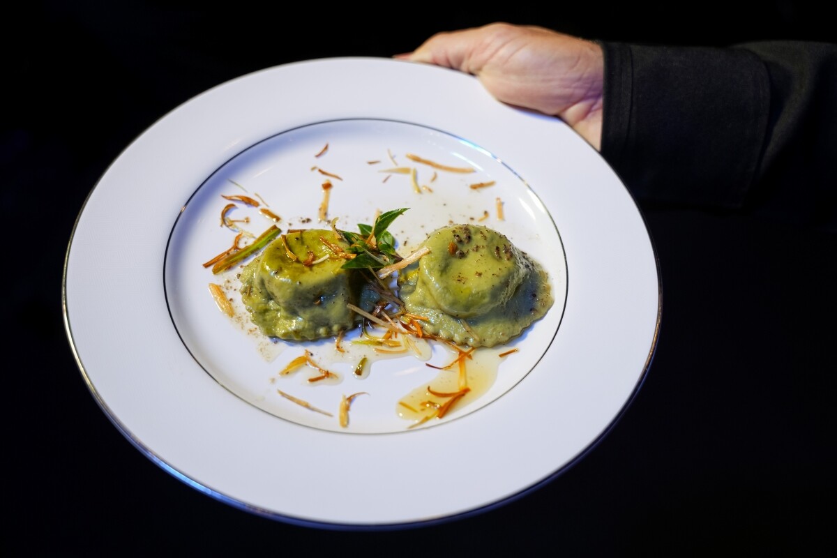 Ravioli verde recheado com queijo de cabra e geleia de figo, finalizado com manteiga trufada e crispy de alho poró